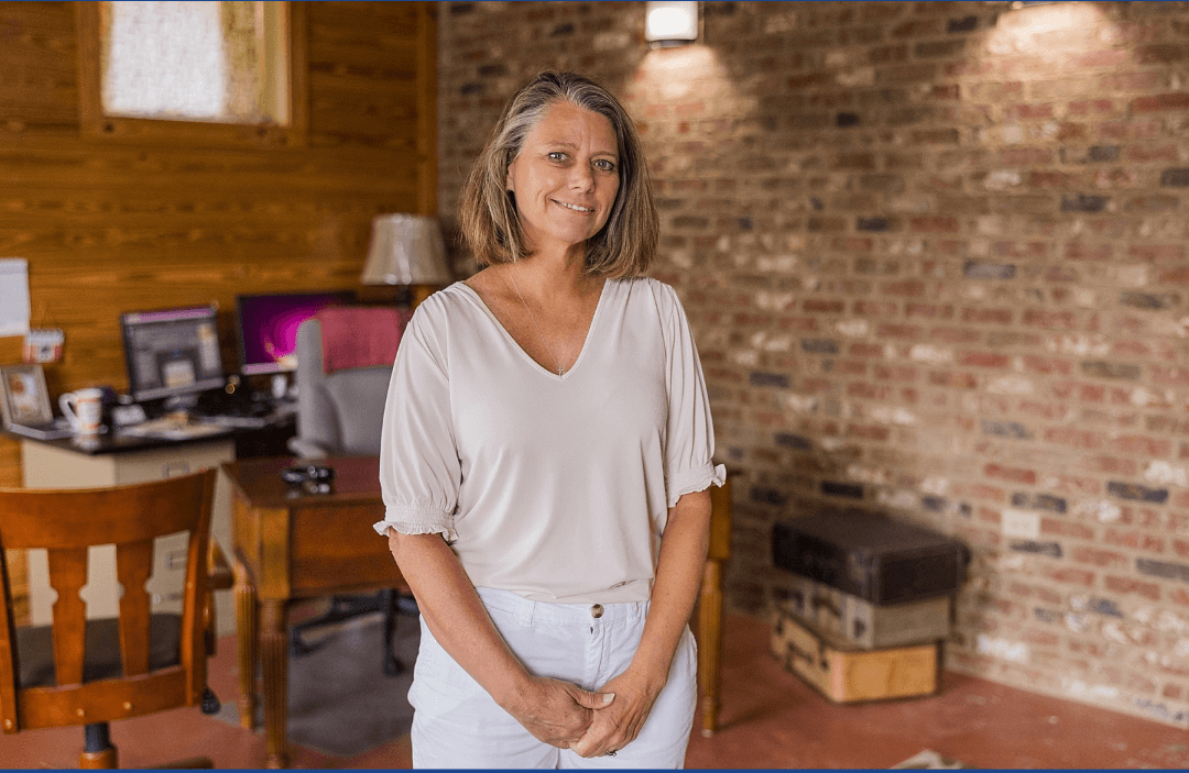 Woman standing in front of a desk.